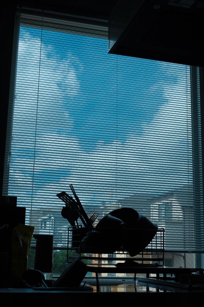 窓ガラスに映り込んだ、夏の入道雲と青空